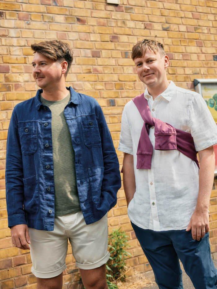 man in shorts and denim jacket and man in shirt and trousers